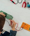 Digital Multimeter With Buzzer Three And A Half Digit LCD Display Voltage Current And Resistance Tester on table with circuit board