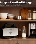 Three In One Waffle Maker with removable plates stored vertically in kitchen cabinet alongside bowls, pot, and coffee machine.