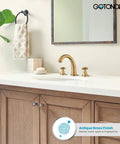 Bathroom vanity with antique brass faucet set, cross handles, and a mirror reflecting the room, highlighting elegant decor.