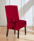 Red chair cover with bow detail on wooden chair in bright setting