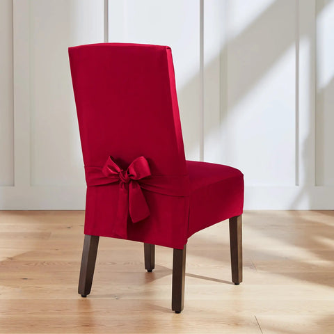 Red chair cover with bow detail on wooden chair in bright setting