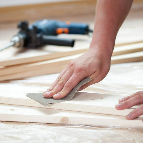 Person using Pro Grade Wet And Dry Sandpaper Set Of 30 Grit Papers 2000 3000 5000 7000 10000 for sanding wood surface.