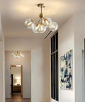 5 Light Amber Glass Globe Chandelier With Brass Gold Finish, Semi Flush Mount Ceiling Light in a modern hallway