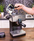 A person adding water to The Real Deal 4 Cup Steam Espresso System With Built In Frothing Arm For Rich Coffee And Creamy Lattes Easy Peasy Setup.