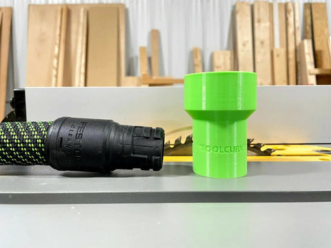 Hose Adapter For Festool 27mm To Dewalt Milwaukee And Ridgid 2 1 4 Inch Table Saws Delivers Easy Dust Collection And A Cleaner Workshop With Rear Port Compatibility. Green 27mm to 2-1/4 inch adapter beside a hose, on a table saw.