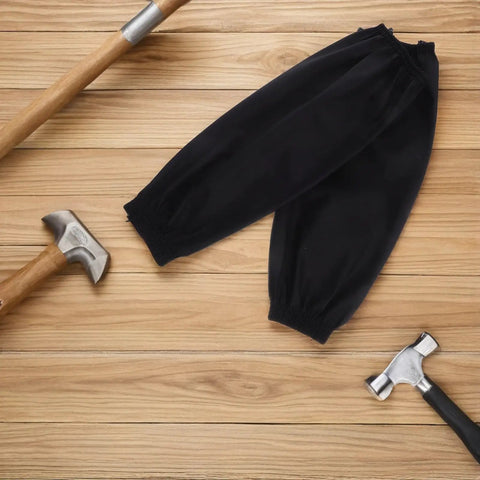 Real Deal Heavy Duty 2 Pair Reusable PU Arm Sleeves Waterproof And Oilproof Oversleeves on wooden surface with hammers.