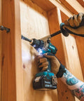 Hands using 18V LXT Brushless Cordless Hammer Drill And Impact Driver Combo Kit With 5.0Ah Batteries in wood drilling task