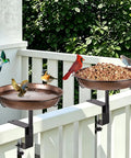 Badass Deck Mounted Metal Bird Bath For Your Backyard Folks With Detachable 12 Inch Birdbath Bowl and No Sweat Adjustable Railing Clamp For Rustproof Outdoors with birds enjoying water and food.