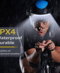 Cyclist wearing duo pack rechargeable LED headlamps with 230 degree wide beam in rain, demonstrating waterproof feature.