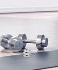 Two Pack Barbell Collar Clamps For Dumbbells And Fitness Gear, Screw Lock Design in silver with dumbbell on floor mat