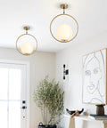 Mid Century Modern Large Globe Pendant Light With Brushed Brass Finish And White Glass Sphere in stylish living room