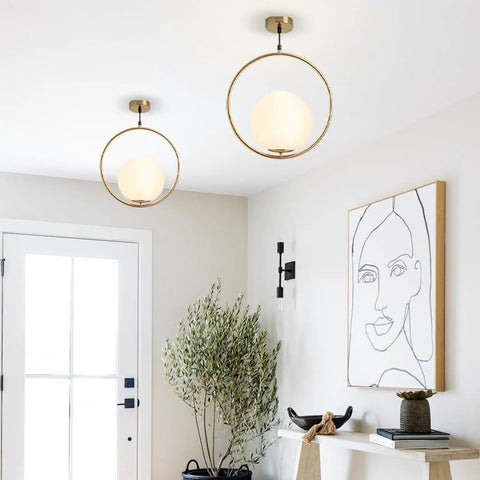 Mid Century Modern Large Globe Pendant Light With Brushed Brass Finish And White Glass Sphere in stylish living room