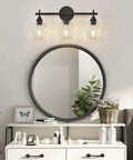Modern Black Industrial Three Light Vanity Light With Wine Glass Shades in a bathroom over a round mirror and vanity