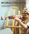 Child playing with Wooden 3D AK47 Puzzle Model With Rubber Band Shooter Detachable Magazine And Two Fire Modes Cool DIY Kit