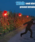 Solar Powered Motion Sensor Alarm System With 129dB Outdoor Siren Waterproof Deterrent strobe lights at night in action.