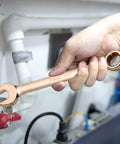 Hand using beryllium copper wrench from Non-Sparking Tools Set 37-Piece Pro Grade Spark Free Safety Kit, tightens pipe fitting.