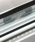 Close-up of a mesh patch from a 50 Piece Window Screen Repair Kit With Self Adhesive Patches And Mesh No Tools Needed For Door And Window Screens Easy To Use Fix Kit For Home Repairs Keeps Bugs Out And Screens Looking Great, applied on a window.