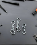 Cotter Pin Hardware Kit With Bow Tie Lock Clips And Spring Pins amid various tools on a dark surface
