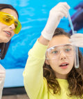 Young girl using Graduated Dropper Pipettes Kit 3 Pack 0.5ml 1ml 5ml Borosilicate Glass with guidance from teacher in science lab