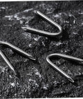Three U Shaped Garden Stakes And Fixing Nails Set For Fences And Ground Anchors Pro Grade 100 Piece U Nails on rocky surface