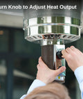 Close-up of adjusting a stainless knob on the Beast 50,000 BTU Outdoor Patio Heater With Round Table Design, for precise heat control.