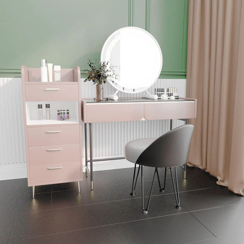 Pink vanity set with round mirror, black chair, and hairpin leg table against green and cream wall.