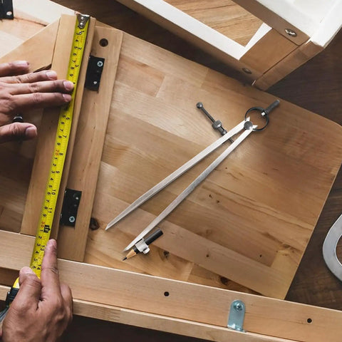 Rock Solid 8 Inch Woodworking Compass And Carbon Steel Scribe Divider With Locking Pin on a workbench with measuring tape.