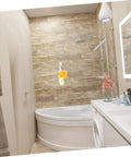 Modern bathroom with corner bathtub, hanging bath sponge, and vibrant flowers on a sleek white countertop.