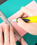 Person using Ultimate 16 Piece Exacto Knife Set With Magnetic Storage Case for crafting, cutting pink foam with precision knife and ruler.