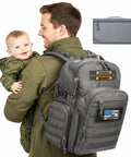 Dad carrying baby and Dad Gear Tactical Diaper Bag Backpack with Changing Pad, Military MOLLE System, Water Resistant 900D Fabric, grey