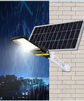 JUDYSSY Solar Street Lights Outdoor Lamp with solar panel on a wall during rain, suitable for dusk to dawn use.
