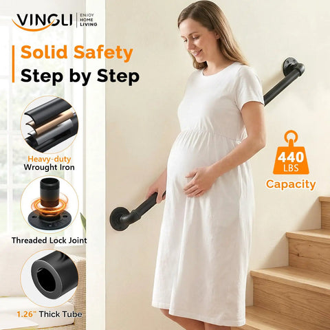 Rock Solid 3 Foot Adjustable Pipe Handrail For Indoor Outdoor Stairs Heavy Duty Wall Mounted Metal Safety Grab Bar Supporting 440 Lbs. A pregnant woman holds the black wrought iron handrail while descending stairs.