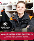 Image of a firefighter with arms crossed, wearing a uniform, standing in front of firefighting gear.