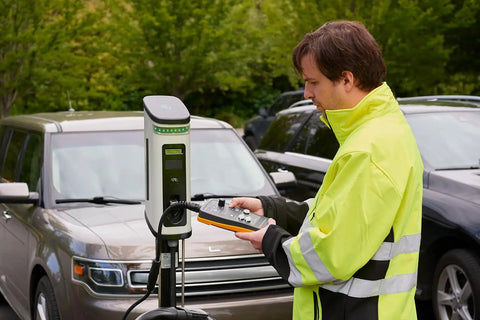 Slick Heavy Duty Type One Electric Vehicle Charging Station Diagnostic Adapter For Testing Level 1 And Level 2 Ac Systems With Gfci And Ground Safety Checks Plug Right In used by a technician at a charging station.