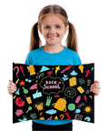 Girl holding back-to-school themed black trifold display board with colorful icons