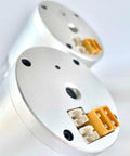 Silver hollow harmonic servo motor joint module with orange terminal blocks and white connectors.