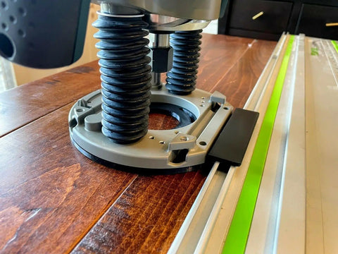 Guide Rail Adapter Fits Bosch 1617 Router Converts Plunge Or Fixed Base To Track Saw System For Dead On Cut Accuracy Uses Original Sub Base Screws For A No Sweat Install Designed And Built In America, close-up view of black steel adapter on wooden surface.