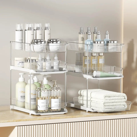 Total Game Changer Clear Three Tier Under Sink Organizer Two Pack showcasing stacked bins with beauty products and towels.