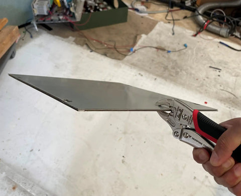 7.5 Inch Heavy Duty Locking Pliers with Screw Extractor and Curved Jaws holding a metal sheet in workshop setting