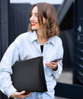 Woman holding 10 Point 5X16 Inch Bubble Mailers 40 Pack Self Seal Padded Envelopes Waterproof Cushioning Mailers, in a black design outdoors