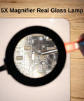 Close-up of 2 In 1 Magnetic Helping Hands Soldering Station with 5X LED magnifying lamp focusing on PCB details on silicone mat.