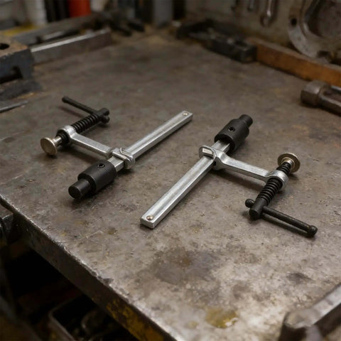 Two Pack Beefy Metal Hold Down Clamps For Woodworking 16mm Dog Hole Bench Clips With Ergonomic Handle on a workbench