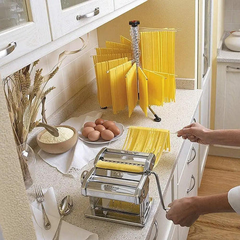 Manual Noodle Press And Dough Roller With Adjusted Thickness Dials delivering homemade pasta, pasta drying rack, flour bowl, and eggs.