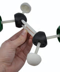 Hand holding Molecular Model Kit With 220 Pieces And 65 Atoms VSEPR Advanced Set For Organic And Inorganic Chemistry with green and black atoms