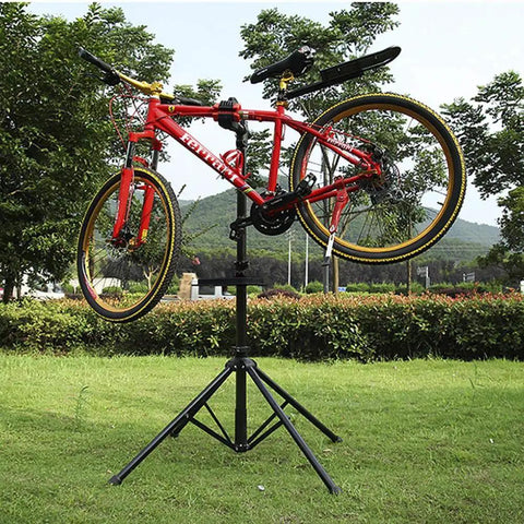 Red bike on Pro Grade Bike Repair Stand For Road And Mountain Bikes With Four Leg Stability Telescoping Arm Quick Release Tool Tray