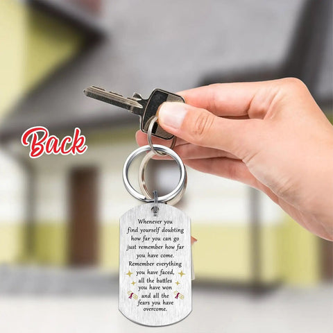 Back view of engineer graduation gift dog tag keychain for Class of 2026 with engraved message, held in a hand.