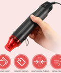 Compact 3 Pack Heat Gun Hot Air Tool For Crafting And Epoxy Resin Projects Fast Heating Blower For Vinyl Wrap And Paint Drying Sleek 300W Black Device with red nozzle held in hand.