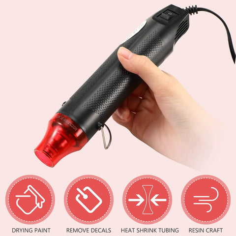 Compact 3 Pack Heat Gun Hot Air Tool For Crafting And Epoxy Resin Projects Fast Heating Blower For Vinyl Wrap And Paint Drying Sleek 300W Black Device with red nozzle held in hand.