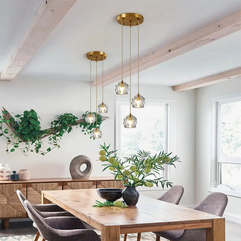 Dining room with Three Light Crystal Cluster Pendant Chandelier In Gold Finish, mid-century modern design above wooden table.