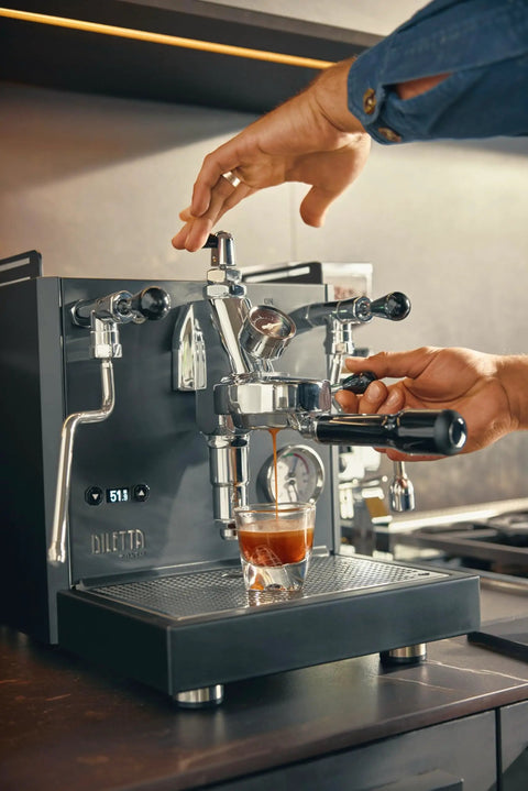 User extracting espresso from the Alto Dual Boiler Espresso Machine With PID Control And Flow Adjustment For Top Shelf Precision Shots With Built In Timer And Pro Steam Paddle In Sleek Stainless Finish.